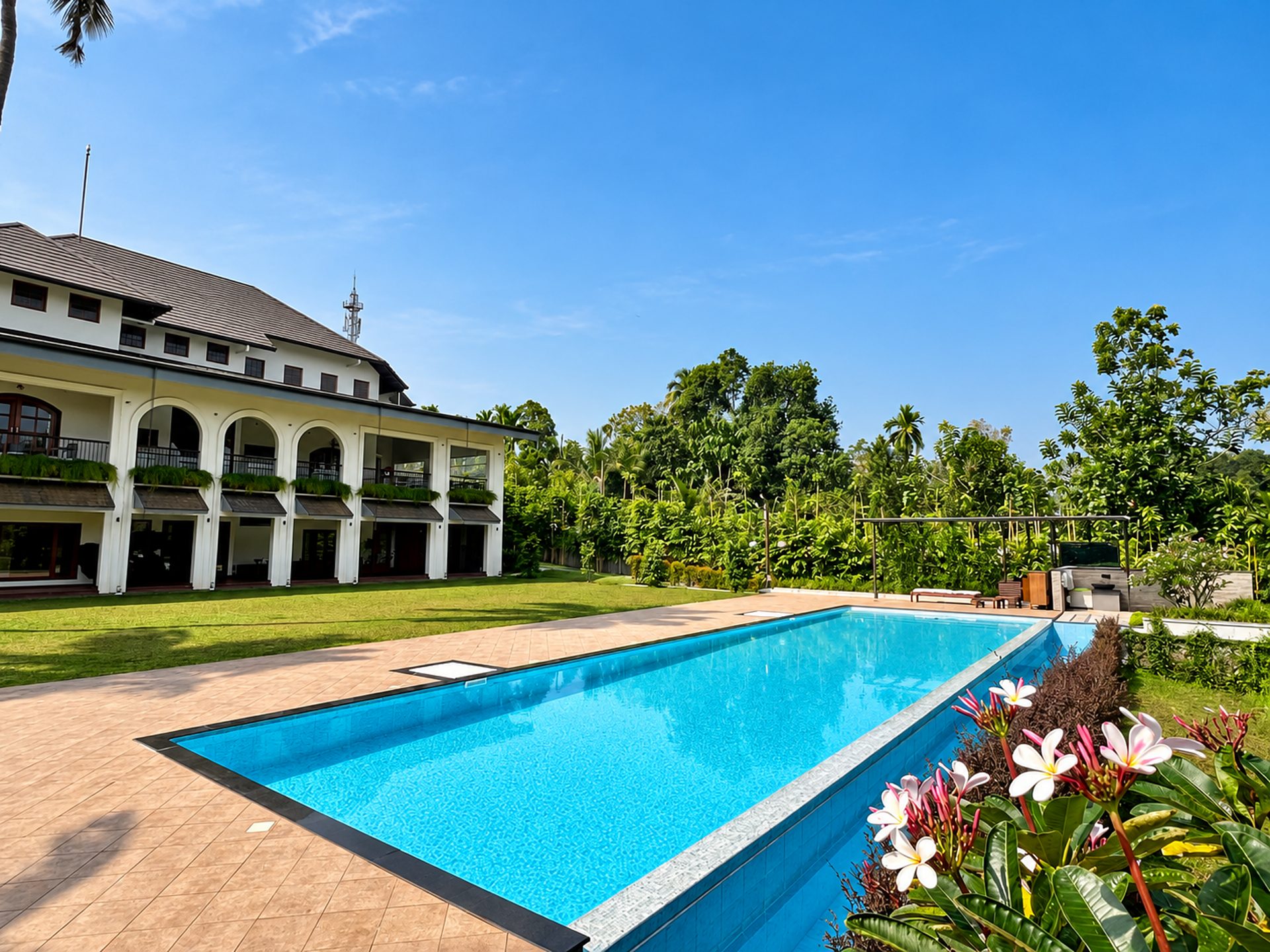 Resort infinity pool framed by gardens, built by Moothedan Projects & Pools